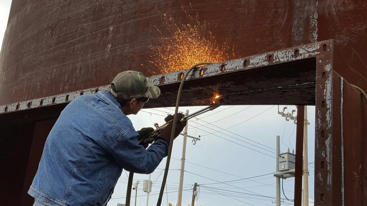 Trabajador cortando metal con soplete